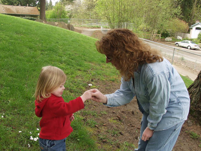emily handing mommy a flower at park